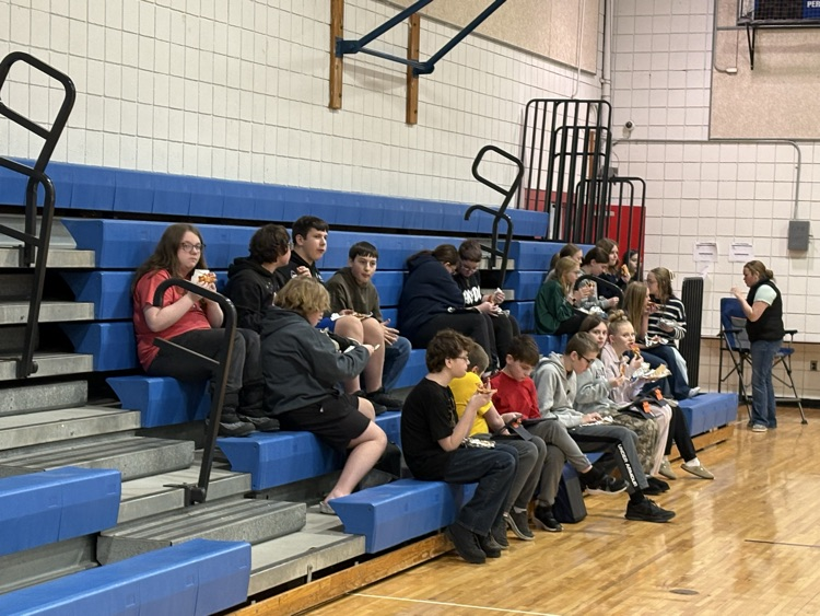 Students eating pizza at reward party.