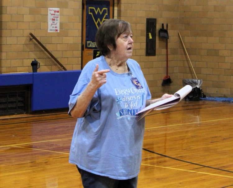 A photo of the FRN Director Debbie Thompson, reading from a paper and presenting to the students and audience