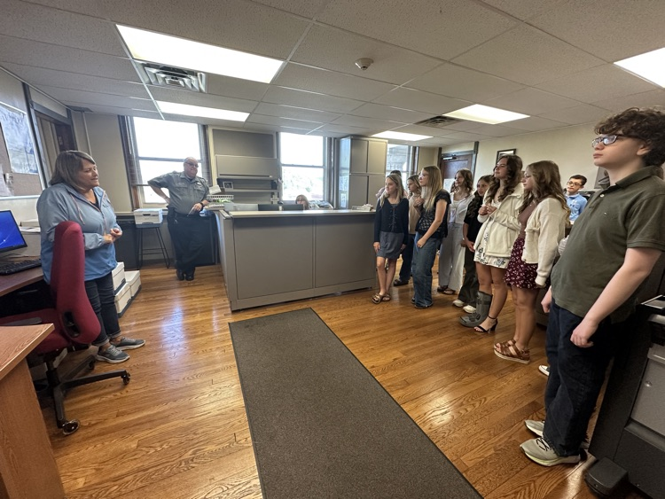 Seventh grade students standing inside the Pleasants County Courthouse, interacting with courthouse employees and observing daily operations during an educational field trip.