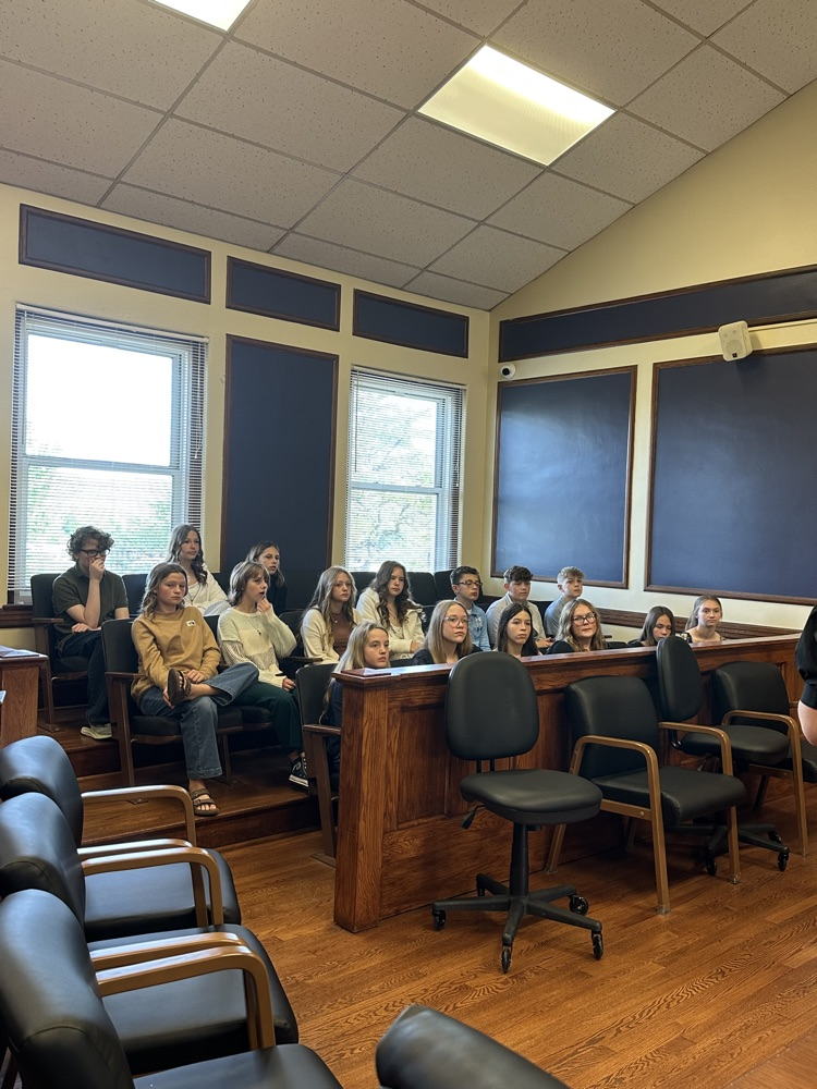Seventh grade students standing inside the Pleasants County Courthouse, interacting with courthouse employees and observing daily operations during an educational field trip.