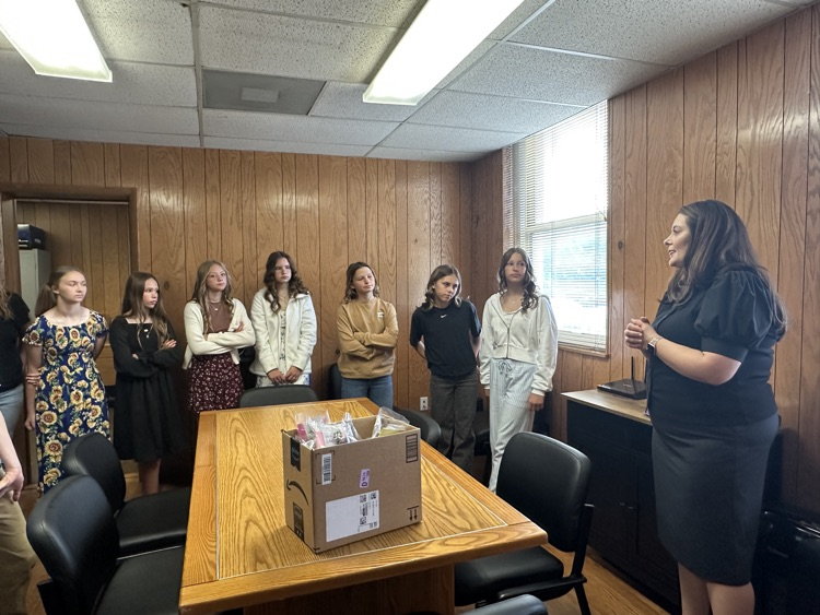 Seventh grade students standing inside the Pleasants County Courthouse, interacting with courthouse employees and observing daily operations during an educational field trip.