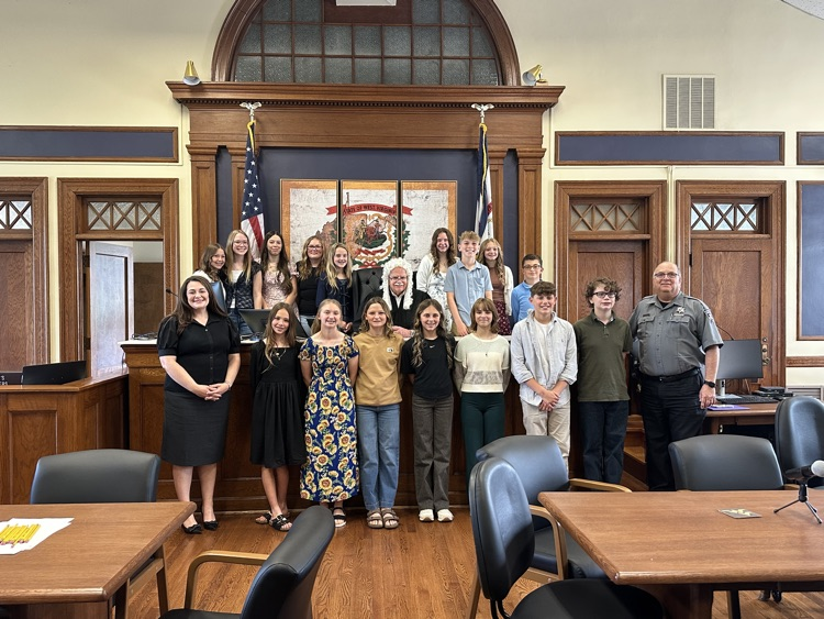 Seventh grade students standing inside the Pleasants County Courthouse, interacting with courthouse employees and observing daily operations during an educational field trip.