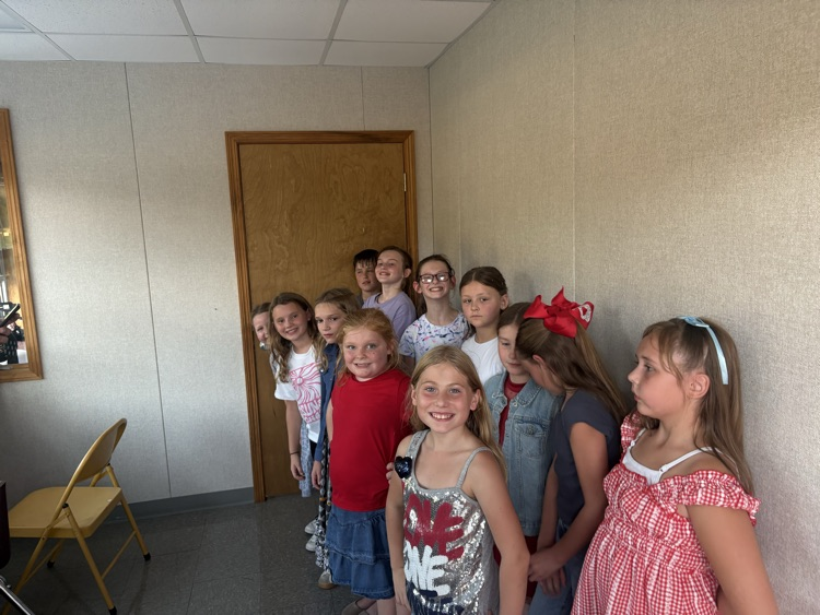 Fourth grade BES choir students performing the Star-Spangled Banner at a Pleasants County Middle School football game, directed by Mr. Negie.