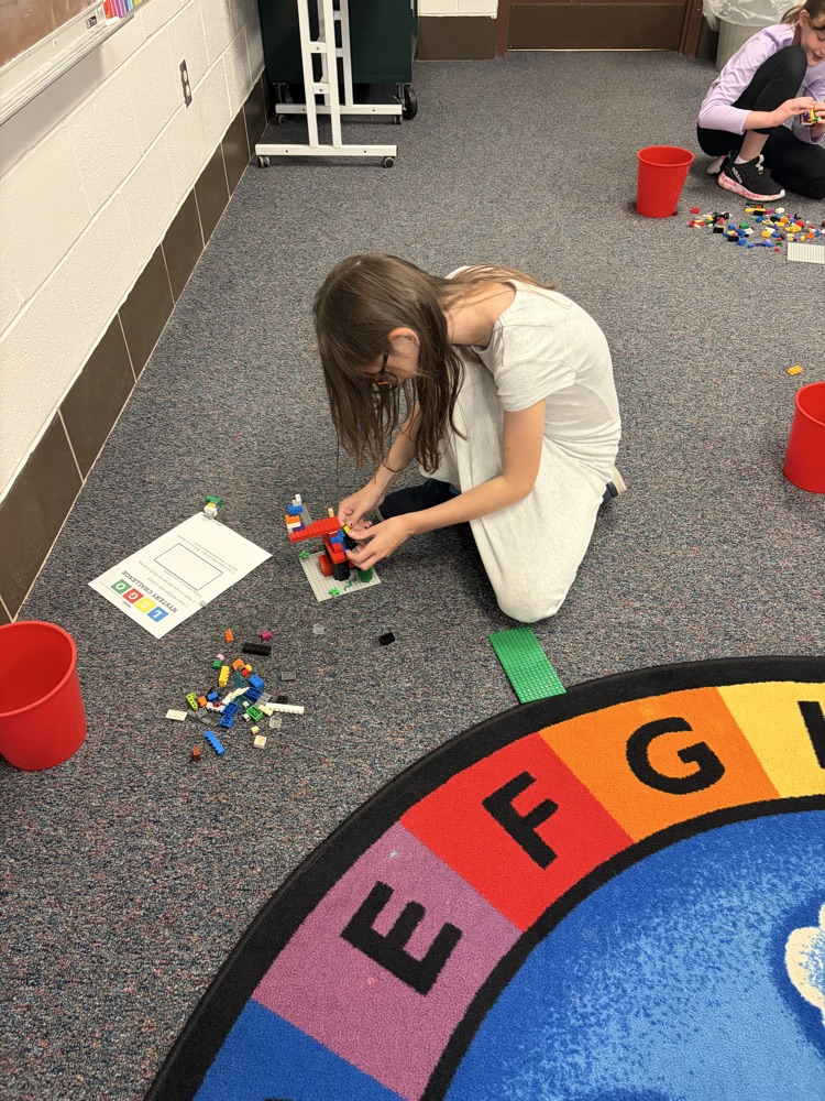 Fourth-grade students complete a mystery LEGO STEAM challenge, building unique creations and competing in a student-voted display.