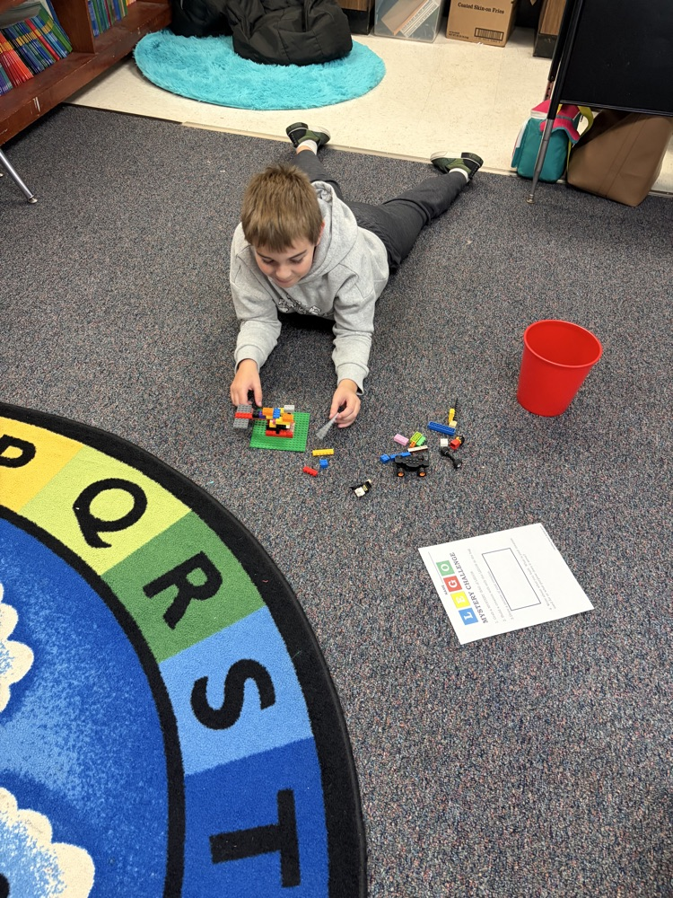Fourth-grade students complete a mystery LEGO STEAM challenge, building unique creations and competing in a student-voted display.