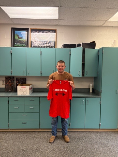 student holding shirt