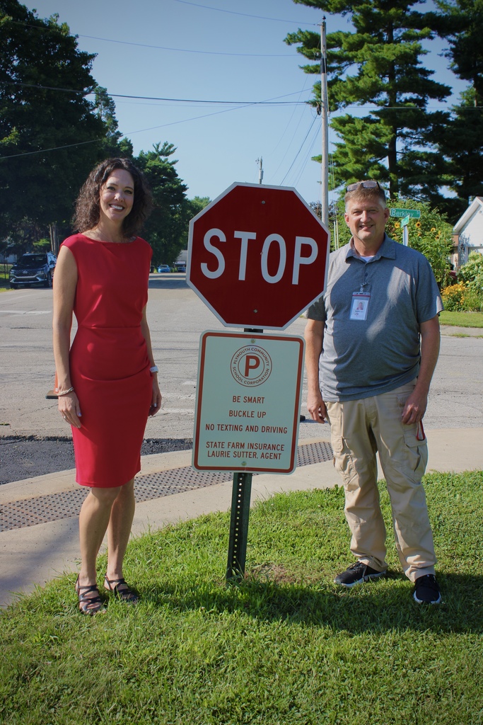 Laurie Sutter and Director of Security and Safety near a new safety driving sign donated by her