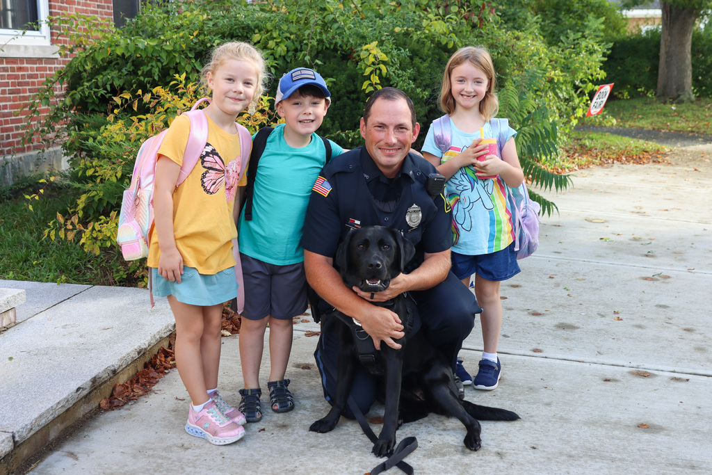 Students posing with Police Officer Shawn Ireland and black lab dog Sasha!