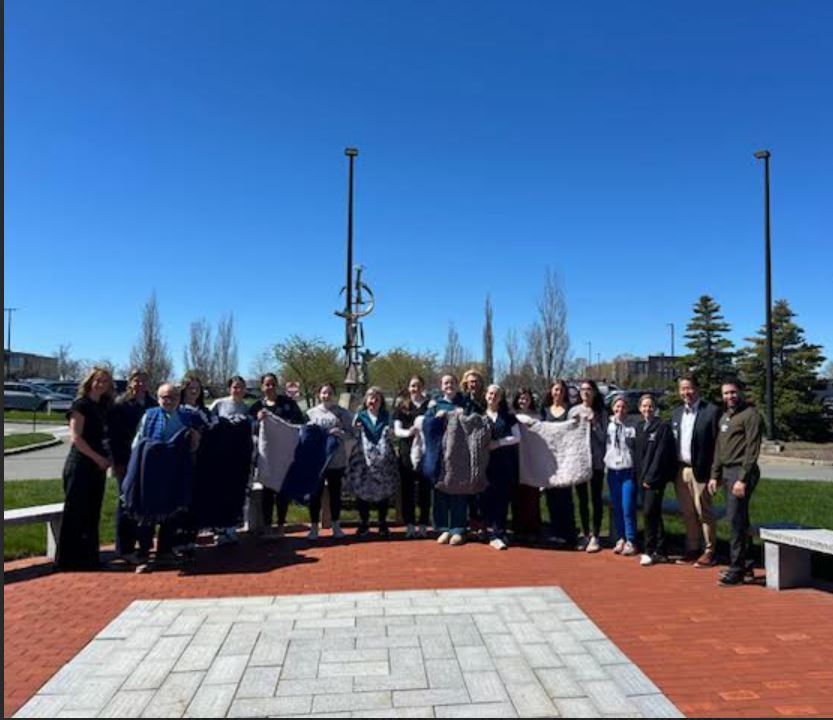 group photo of students and adults with blankets