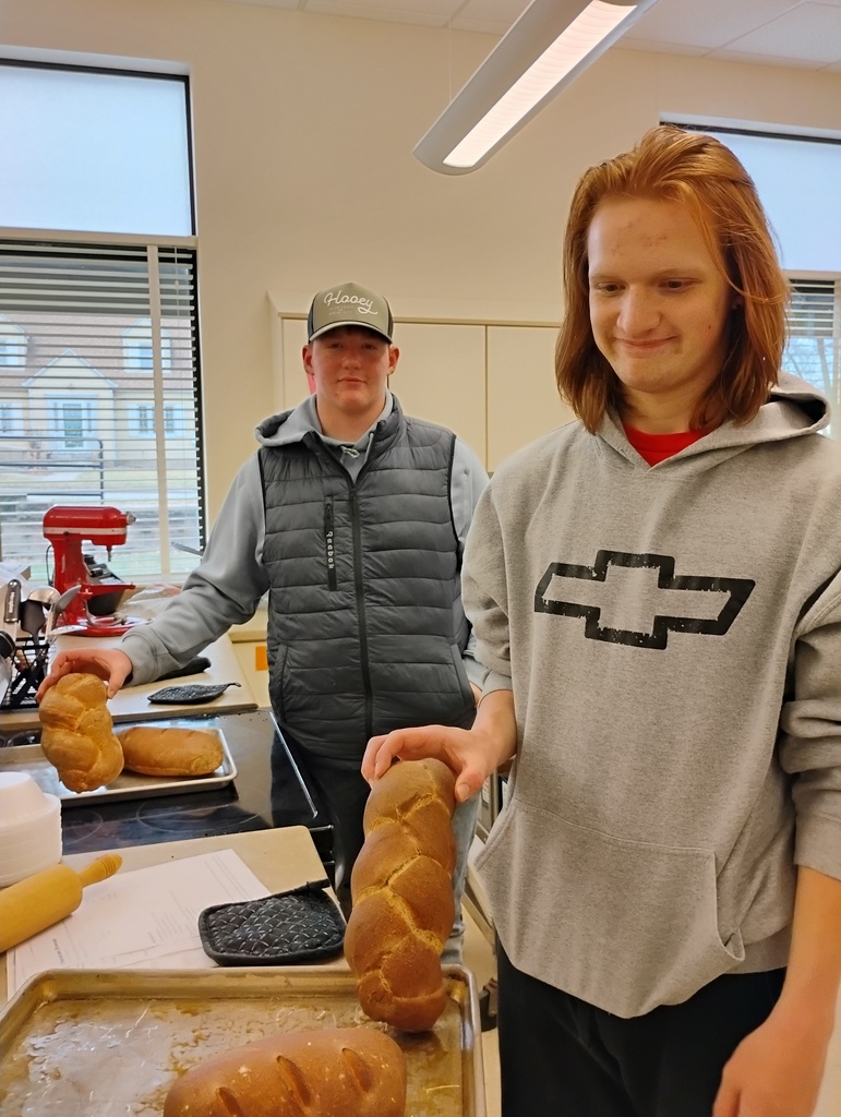 students show off bread they baked
