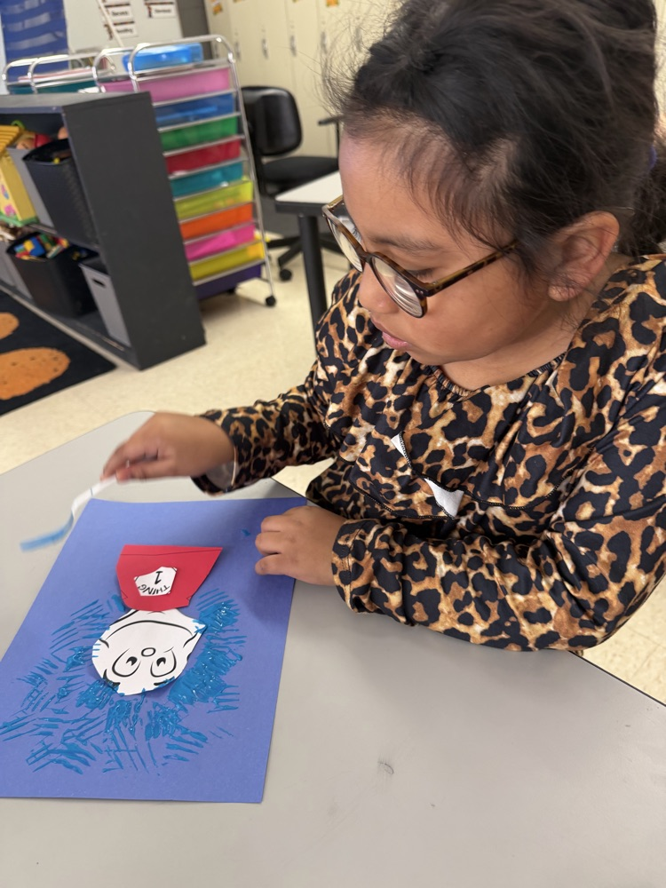 a 1st grader is painting thing 1
