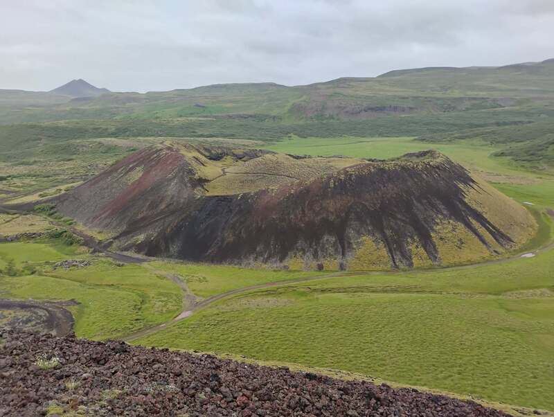 small hill with green and rocks
