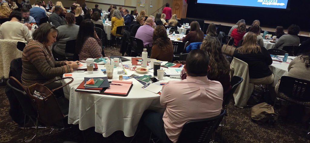 WVDE Conference image with several professionally dressed individuals at tables. Krystal Lewis from MMS is visible on left.