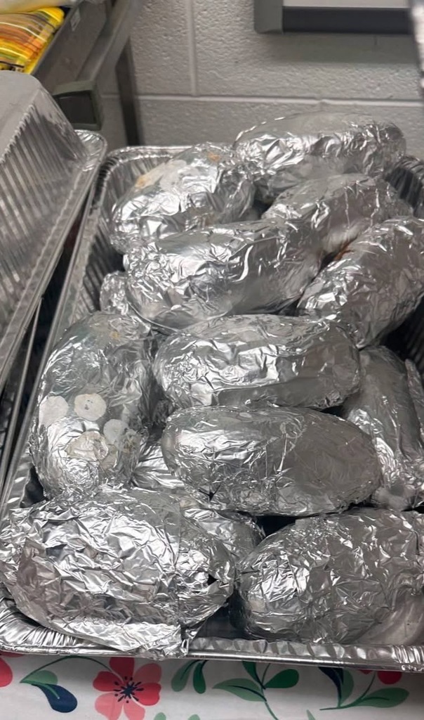 A table displays a lunch setup with baked potatoes