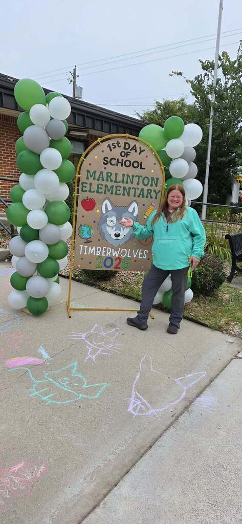 MES staff member in front of back to school sign