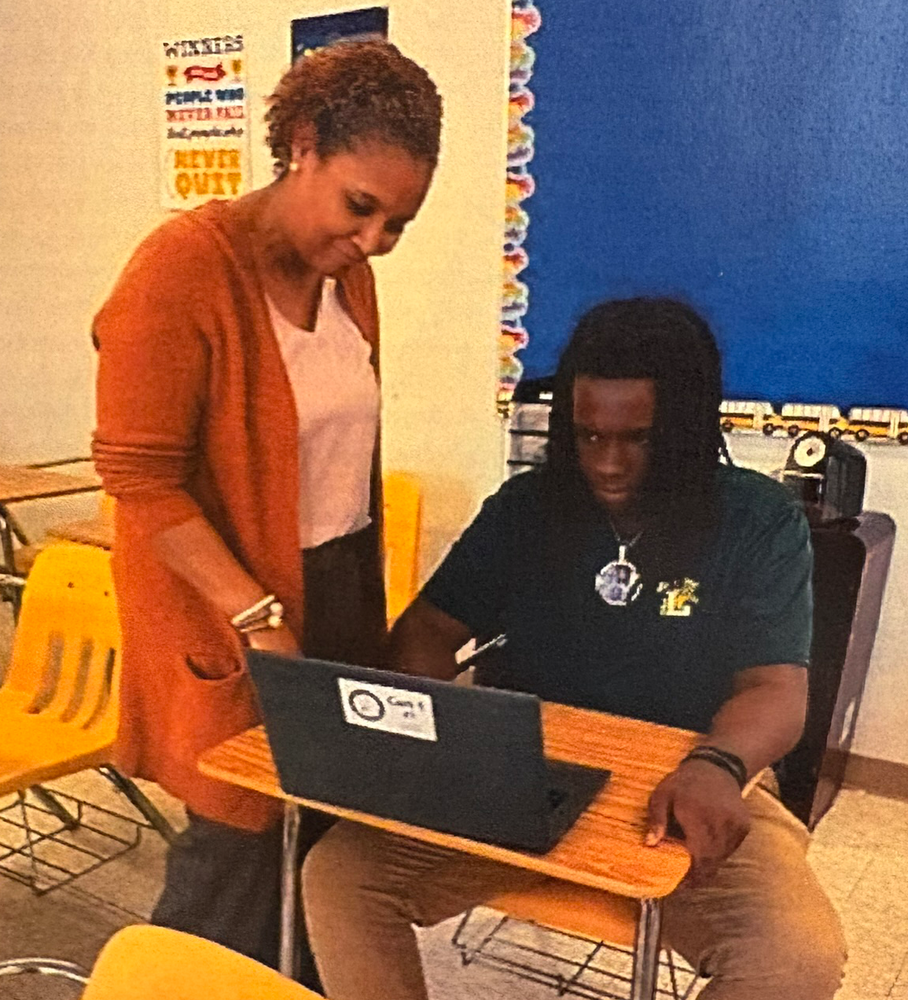 Tomika Henderson works with a student who is on a computer at the Virtual Academy