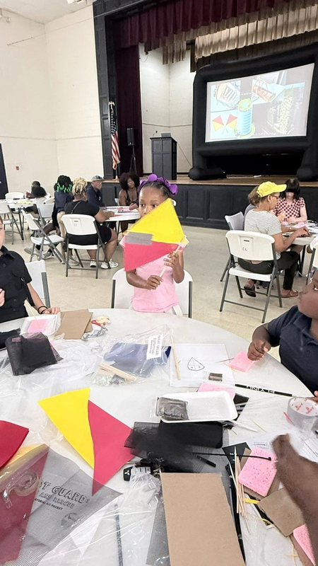 student holding up her craft at the event