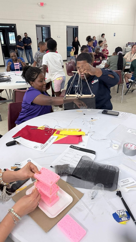student holding up her craft at the event
