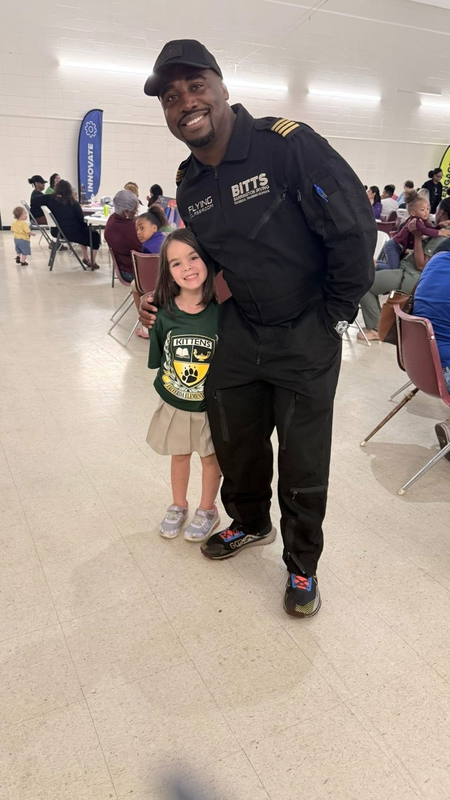 A child posing at the event with an adult
