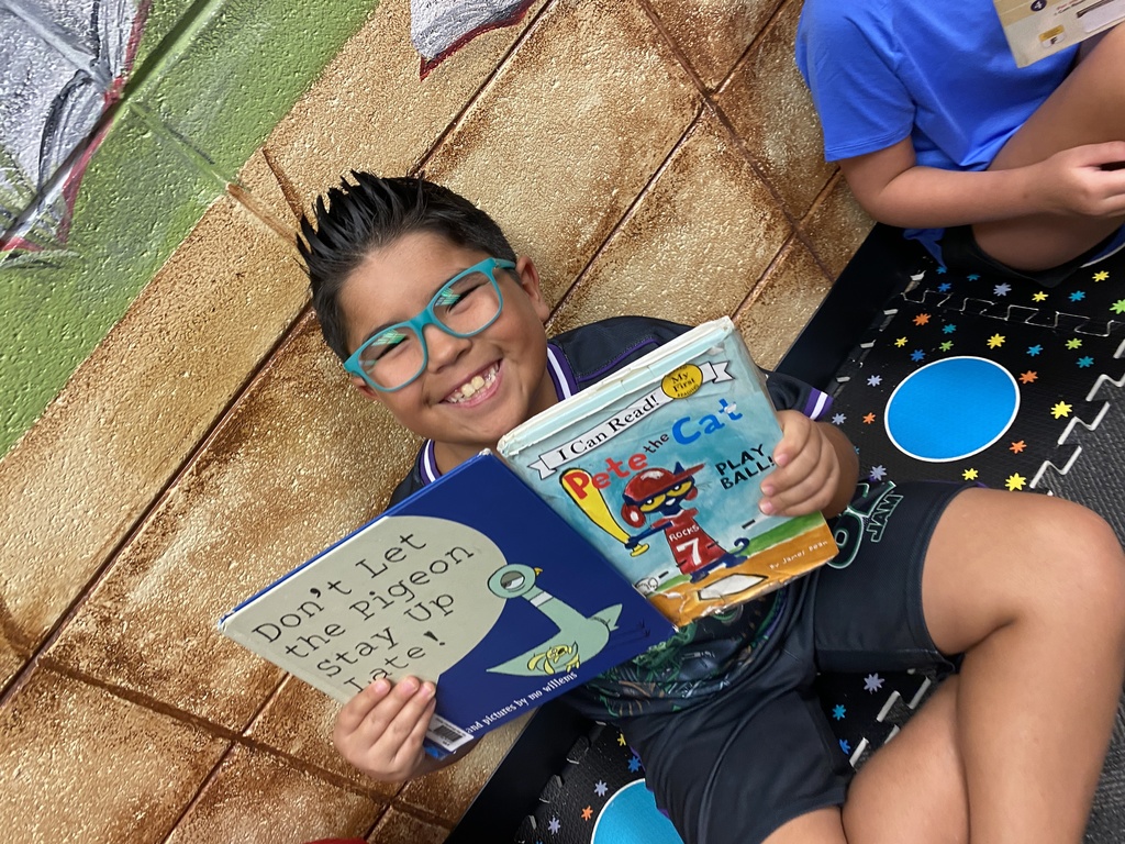 students holding their new library books up and smiling