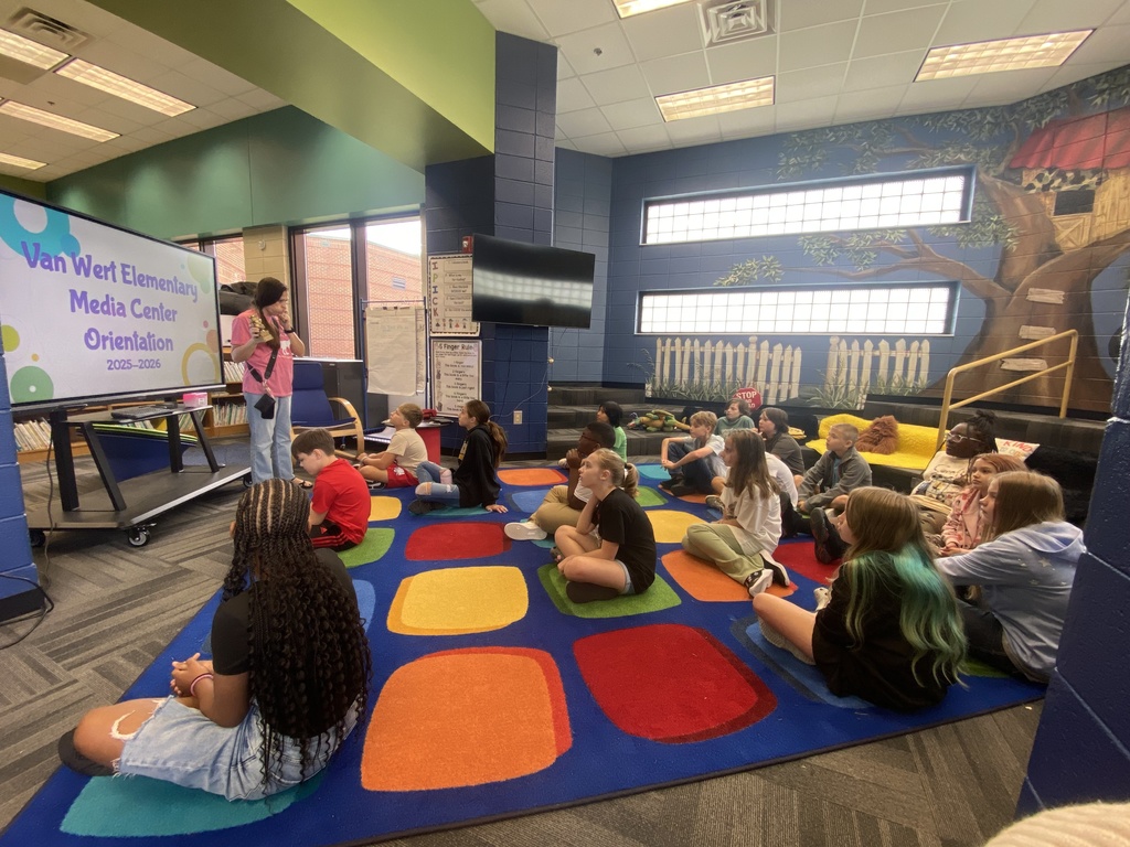 students holding their new library books up and smiling