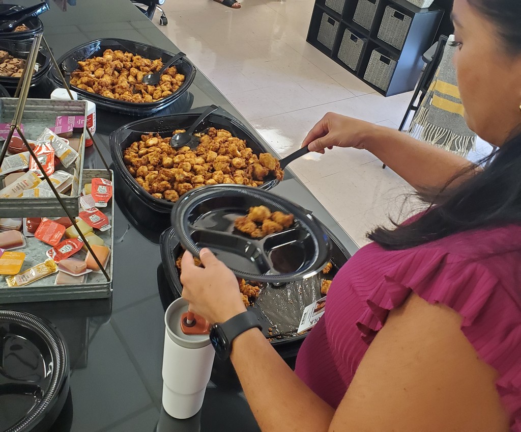 Woman scooping chicken nuggets onto plate