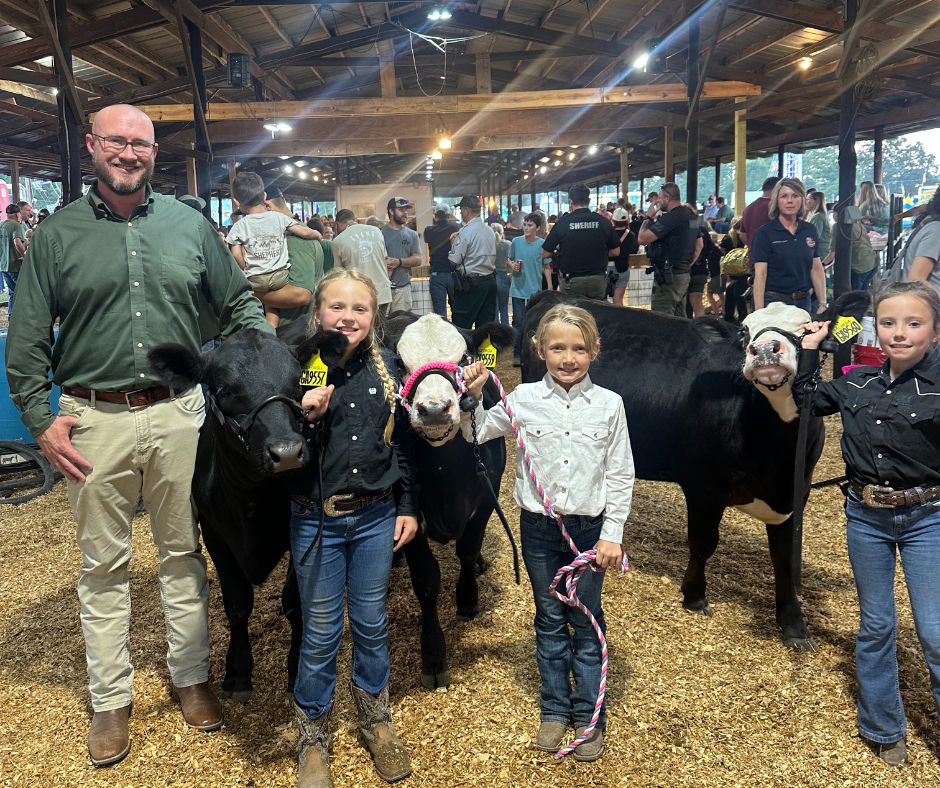 Eastside principal with three students at county cow show