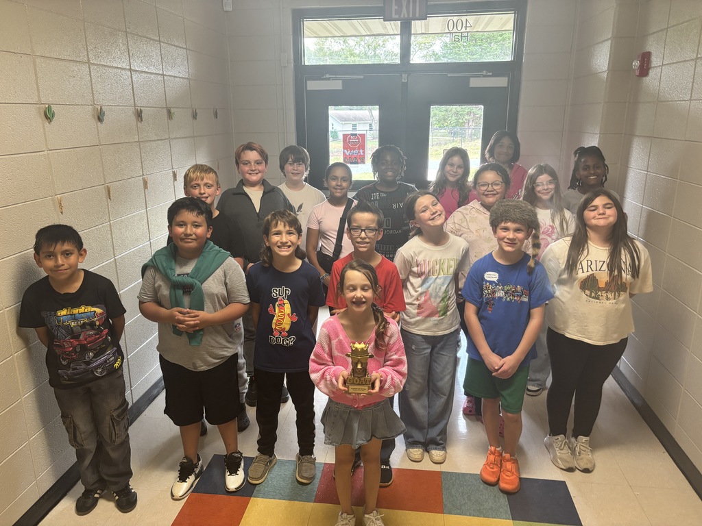 Students posing with the GOAT trophy. 