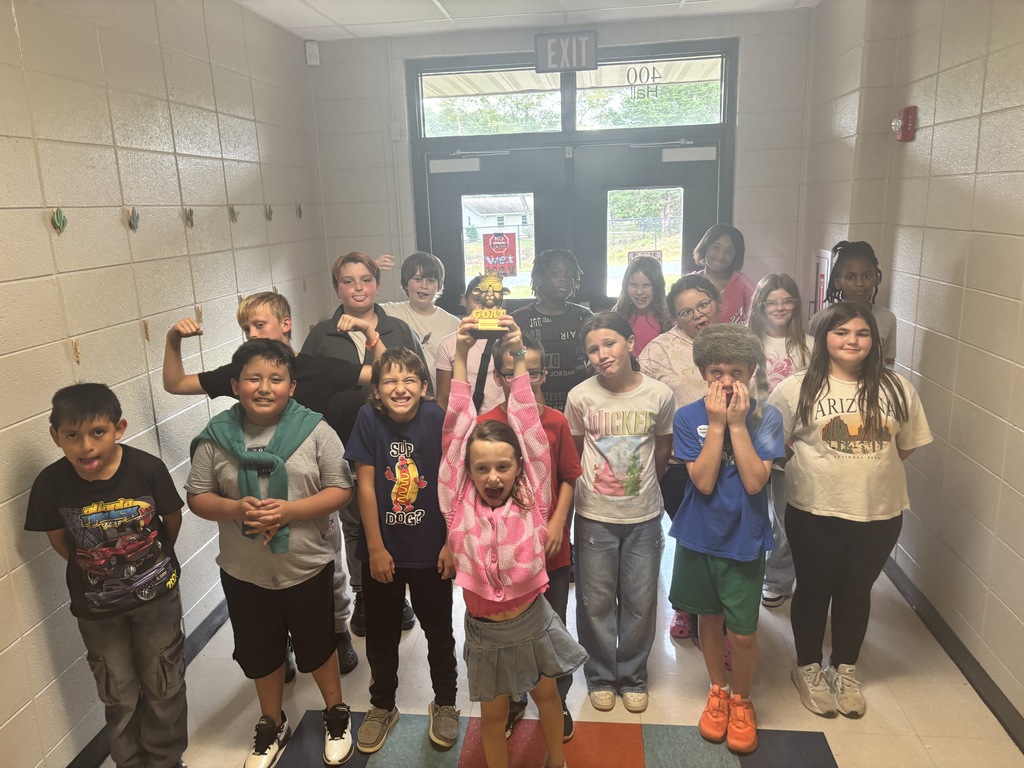 Students posing with the GOAT trophy. 