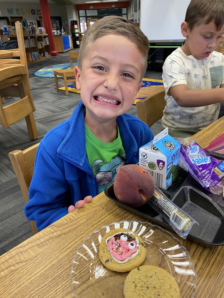 Brayden smiling for the camera while showing off his decorated cookie. 