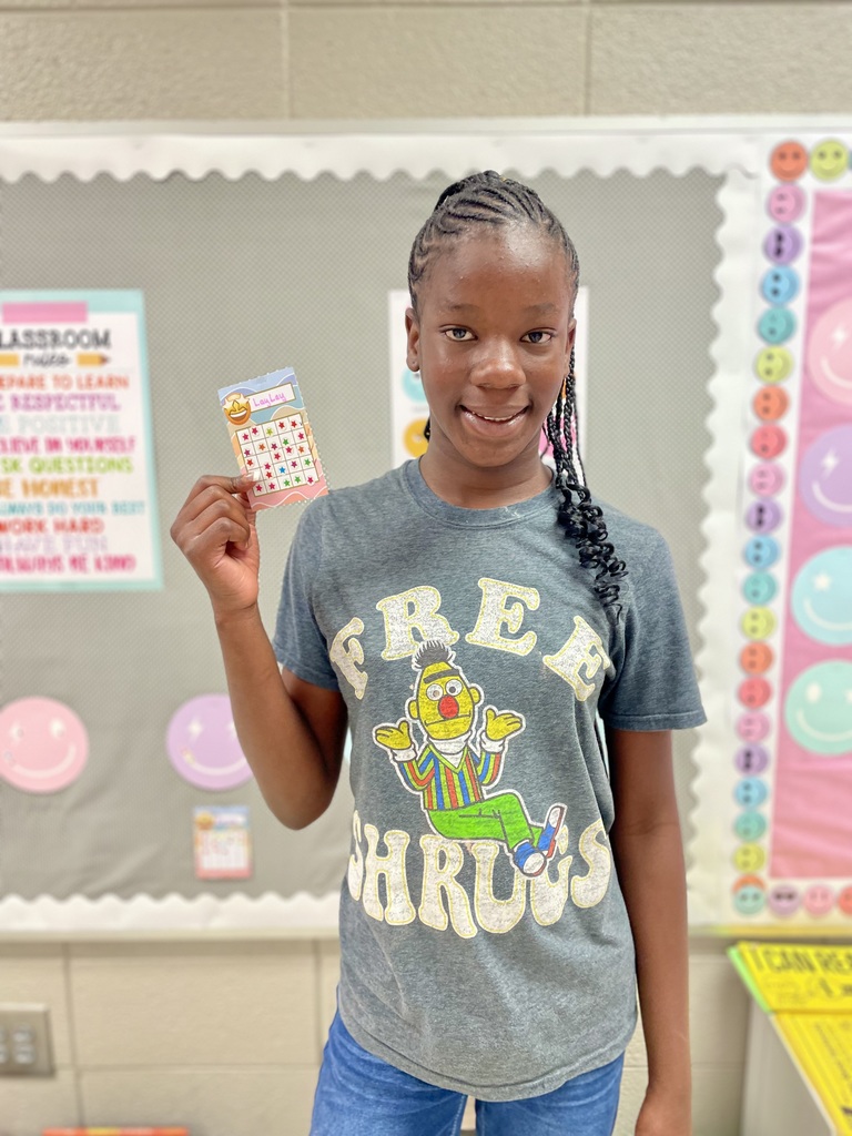 Malaysia posing with her reading card fiilled up and completed.