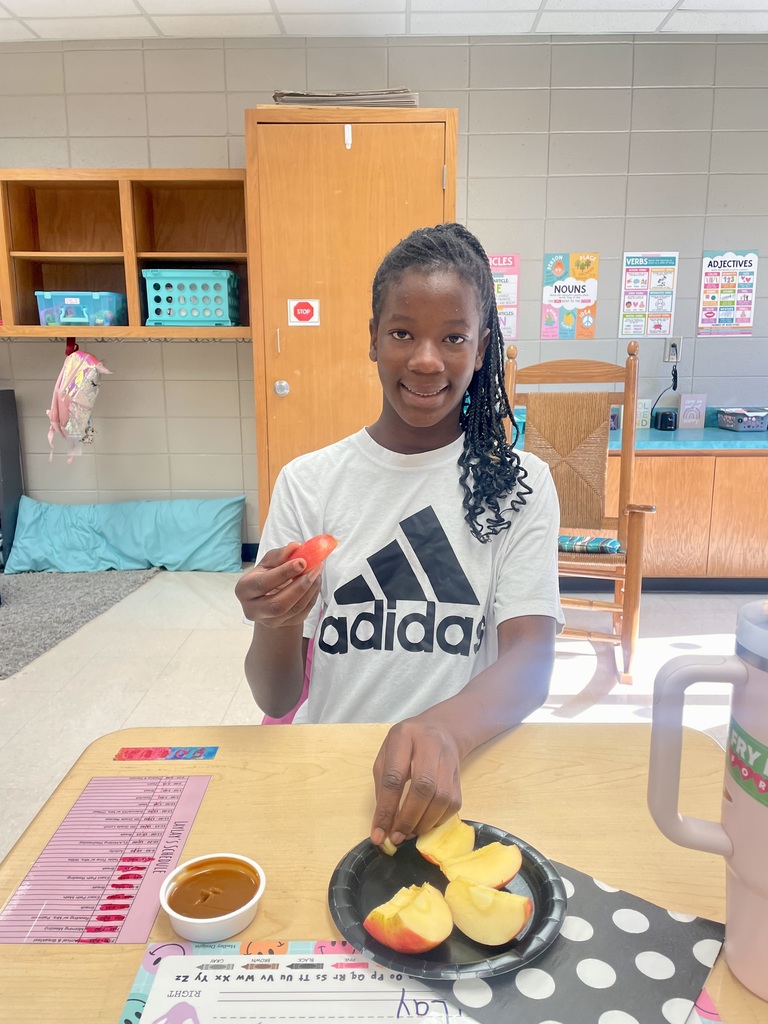 Today, Mrs. Willis' class devoured some delicious Honeycrisp Apples with caramel to go with an autumn science unit while watching a virtual field trip to an apple orchard. 🤎🍎 “I’m loving it!” ~Carson “These are tasty! ~Aurora “This is so good!” ~Eli “They’re good & sweet!” ~LayLay A student smiling with an apple in the picture.