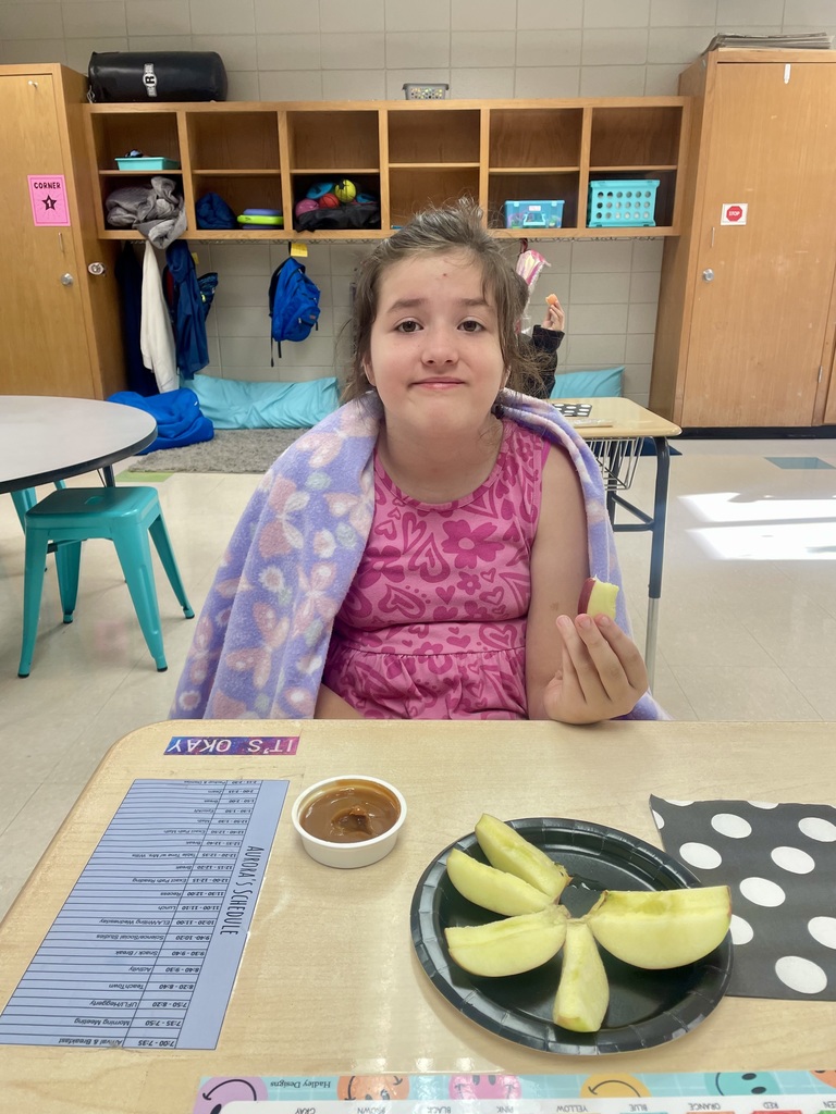 Today, Mrs. Willis' class devoured some delicious Honeycrisp Apples with caramel to go with an autumn science unit while watching a virtual field trip to an apple orchard. 🤎🍎 “I’m loving it!” ~Carson “These are tasty! ~Aurora “This is so good!” ~Eli “They’re good & sweet!” ~LayLay A student smiling with an apple in the picture.