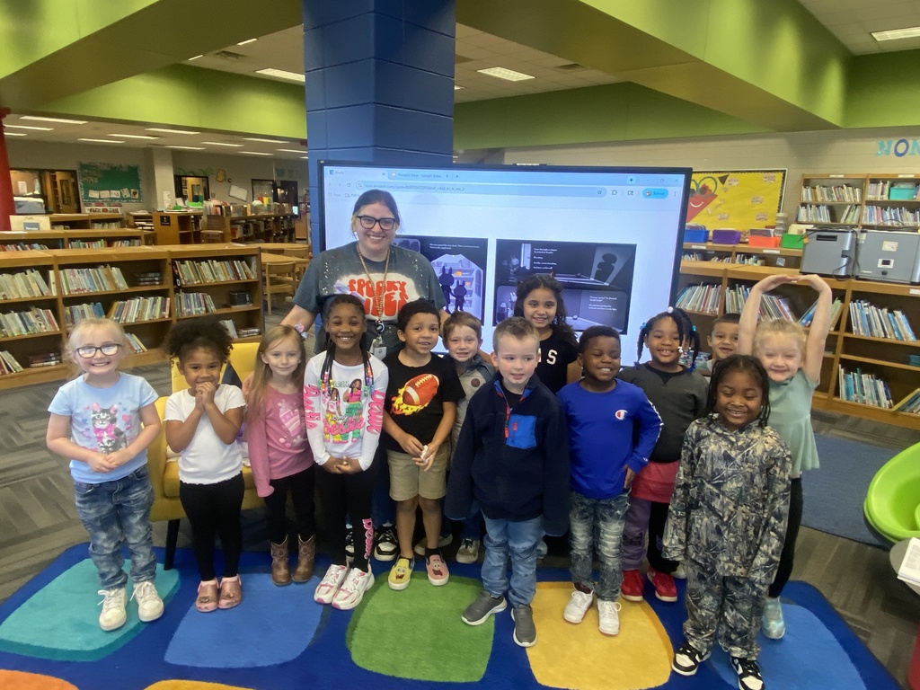Ms. Williams' class posing with Mrs. Booker after she revealed who she was. 