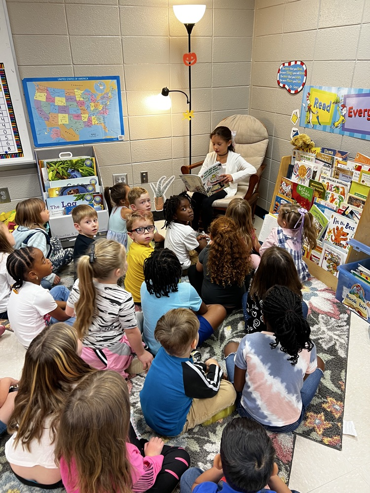 Ava reading to a class.