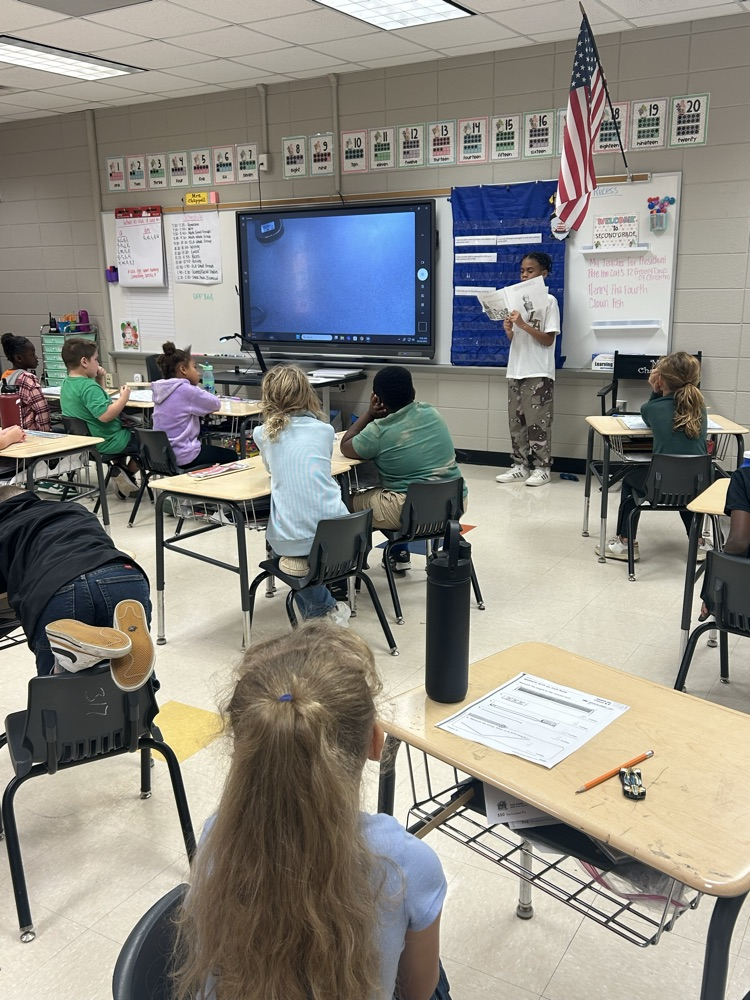 a student reading to a class