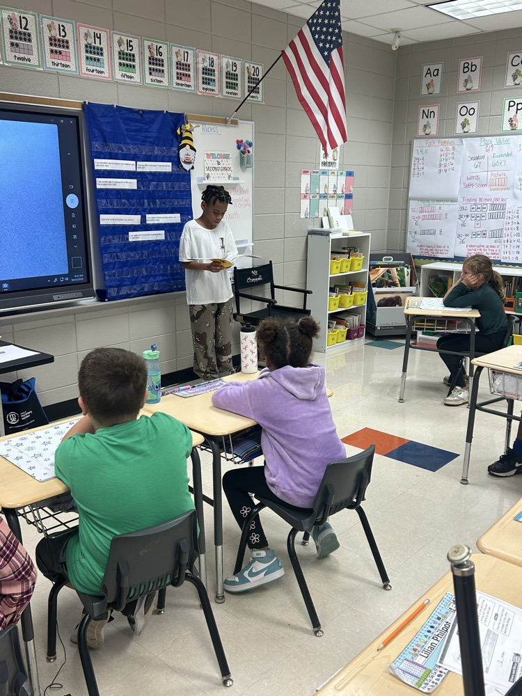 a student reading to a class