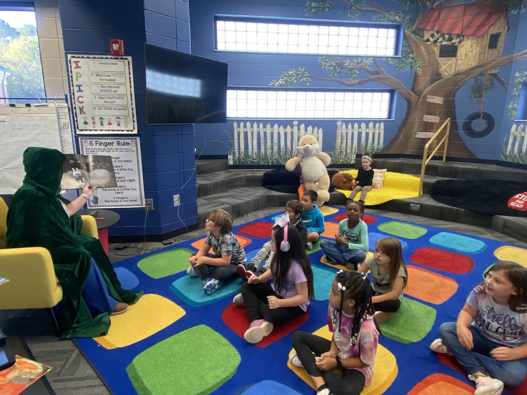 Mrs. Morris reading a book as a mystery reader to Mr. Bostwick's class. 