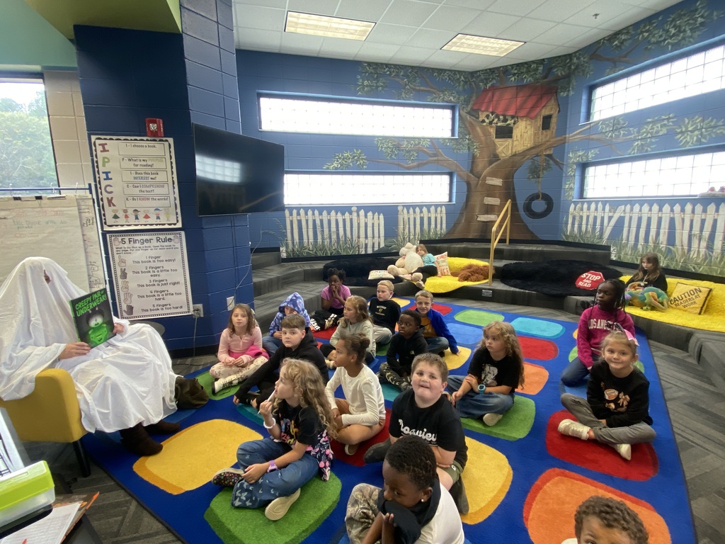 A parent reading a book as a mystery reader to Mrs. Chappell's class. 