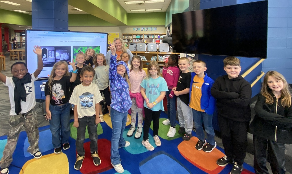 A parent reading a book as a mystery reader to Mrs. Chappell's class. 