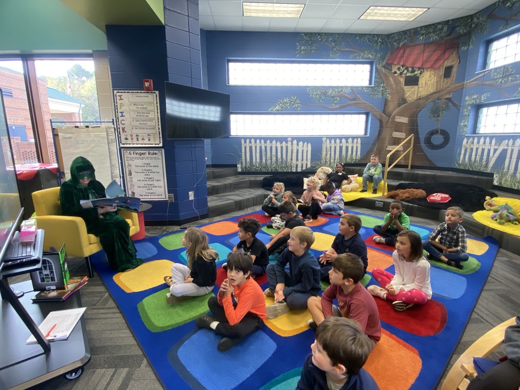 Mrs. Petty reading a book as a mystery reader to Mrs. Cole's class. 