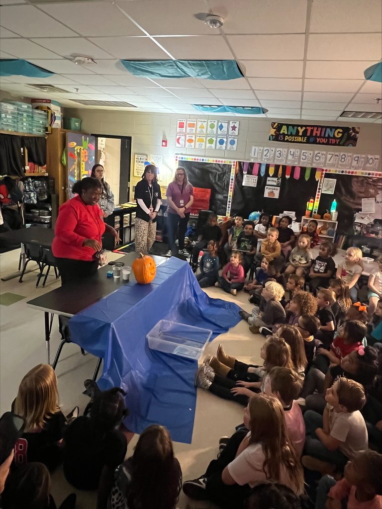 Pumpkin science with kindergarteners - Picture of a pumpkin exploding yellow ooze out it's mouth. Students watching it.