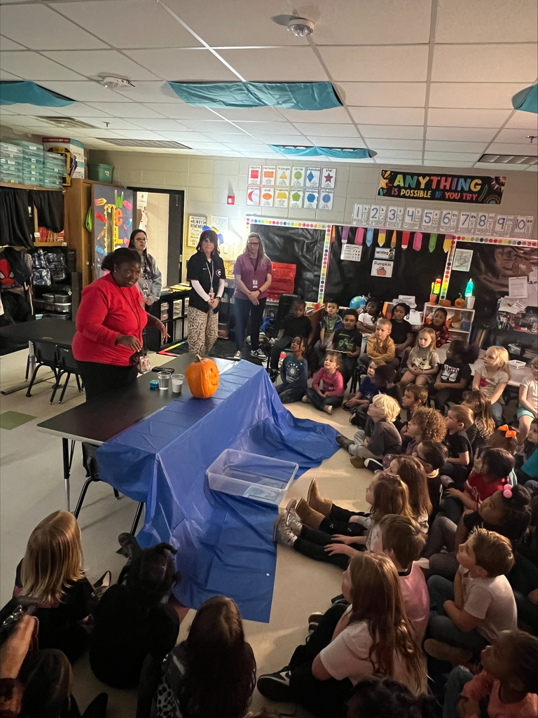 Pumpkin science with kindergarteners - Picture of a pumpkin exploding yellow ooze out it's mouth. Students watching it.