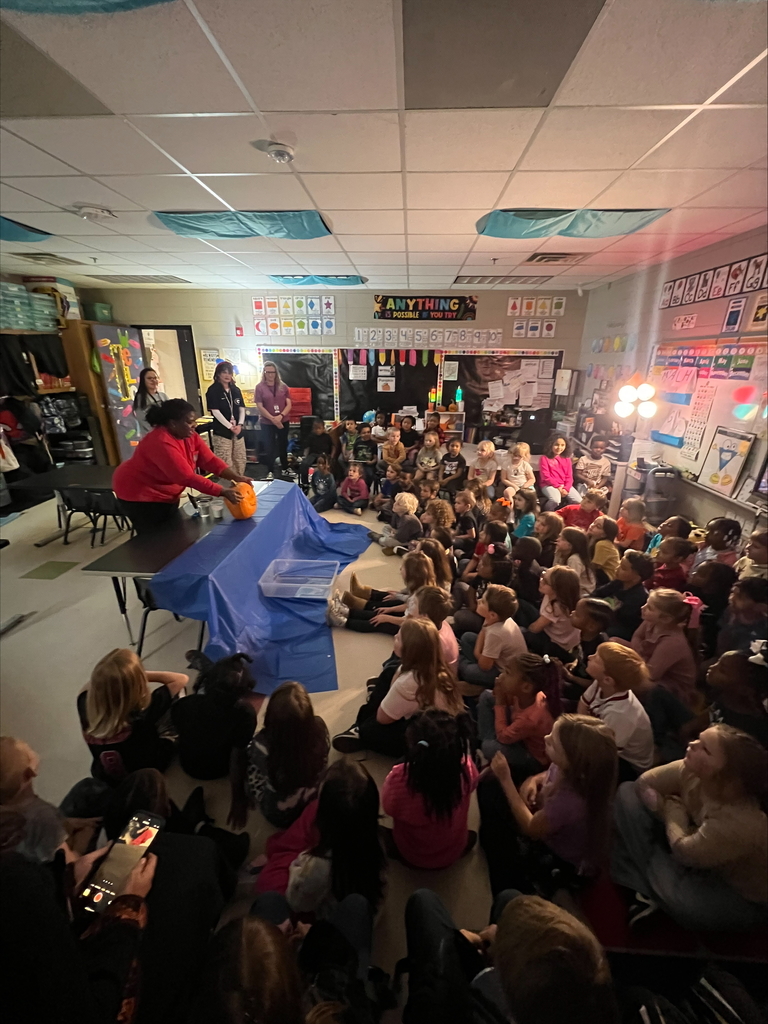 Pumpkin science with kindergarteners - Picture of a pumpkin exploding yellow ooze out it's mouth. Students watching it.