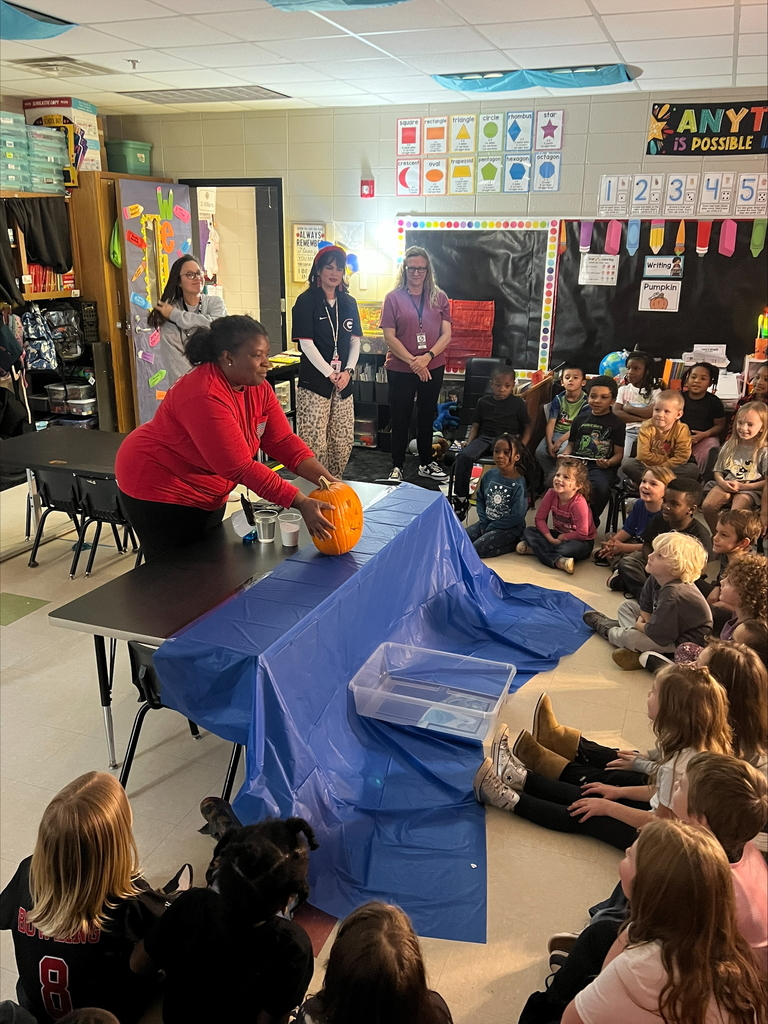 Pumpkin science with kindergarteners - Picture of a pumpkin exploding yellow ooze out it's mouth. Students watching it.