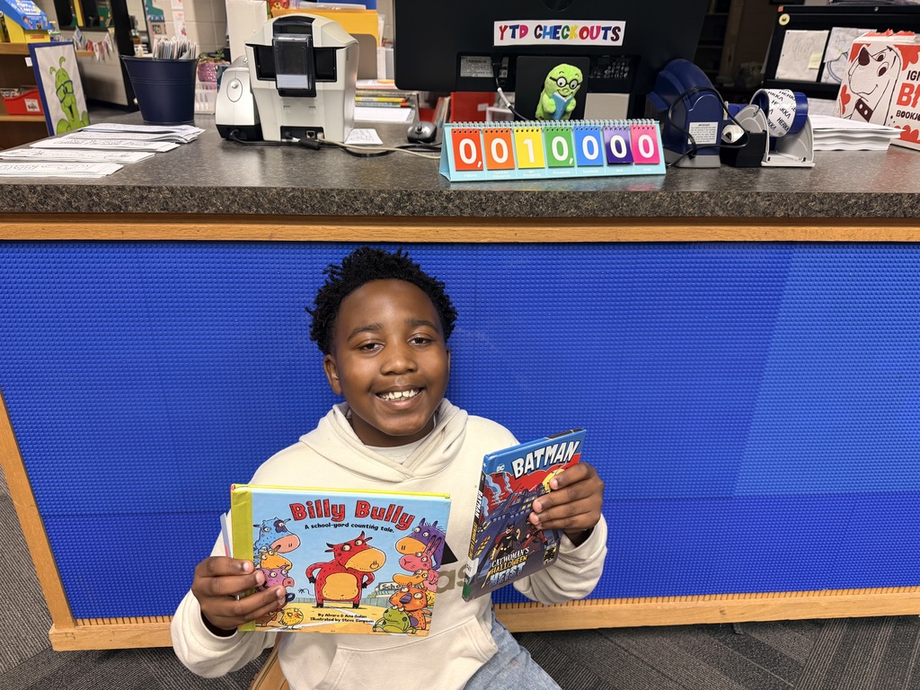 Grayson posing with the 10,000 check outs sign. 