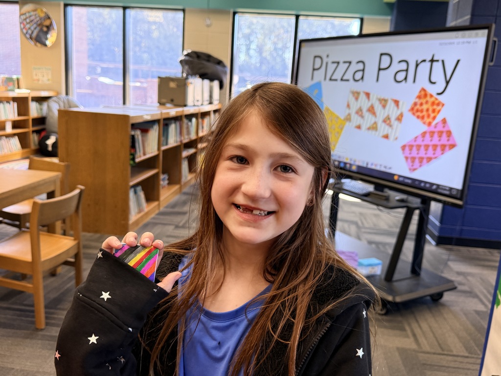 Kids smiling for a picture and eating pizza at the pizza party. 