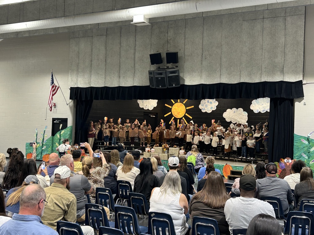 Students in thanksgiving costumes on a stage