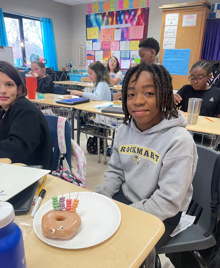 4th grade math is fun with donut turkeys!  picture of kids posing with their donut turkeys 