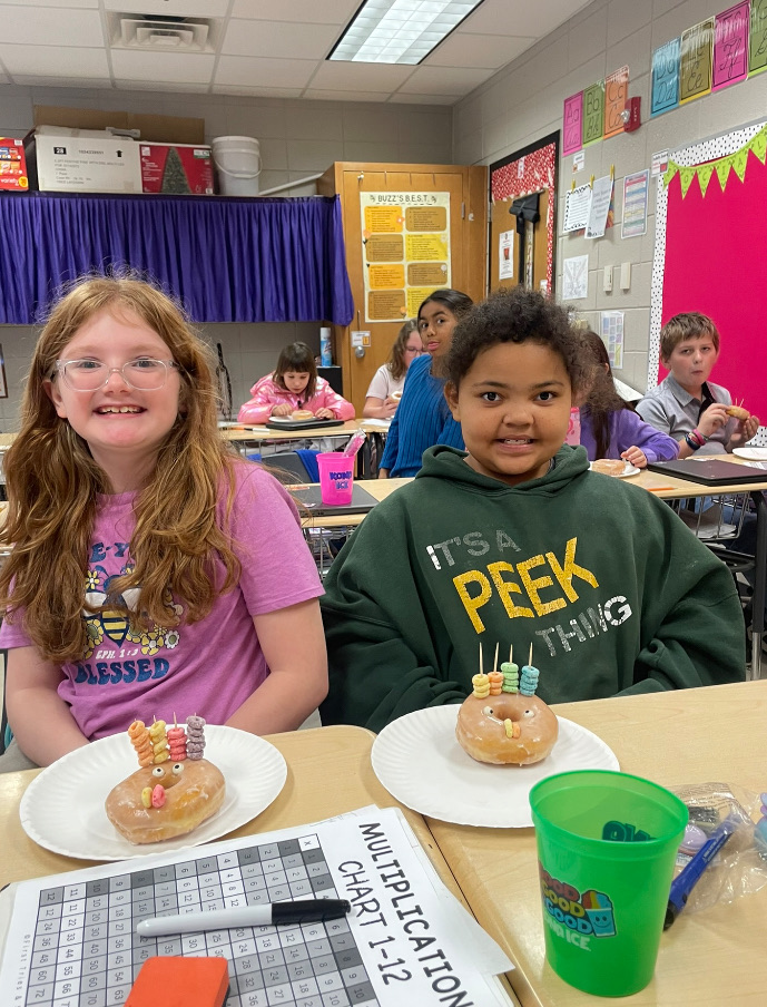 4th grade math is fun with donut turkeys!  picture of kids posing with their donut turkeys 